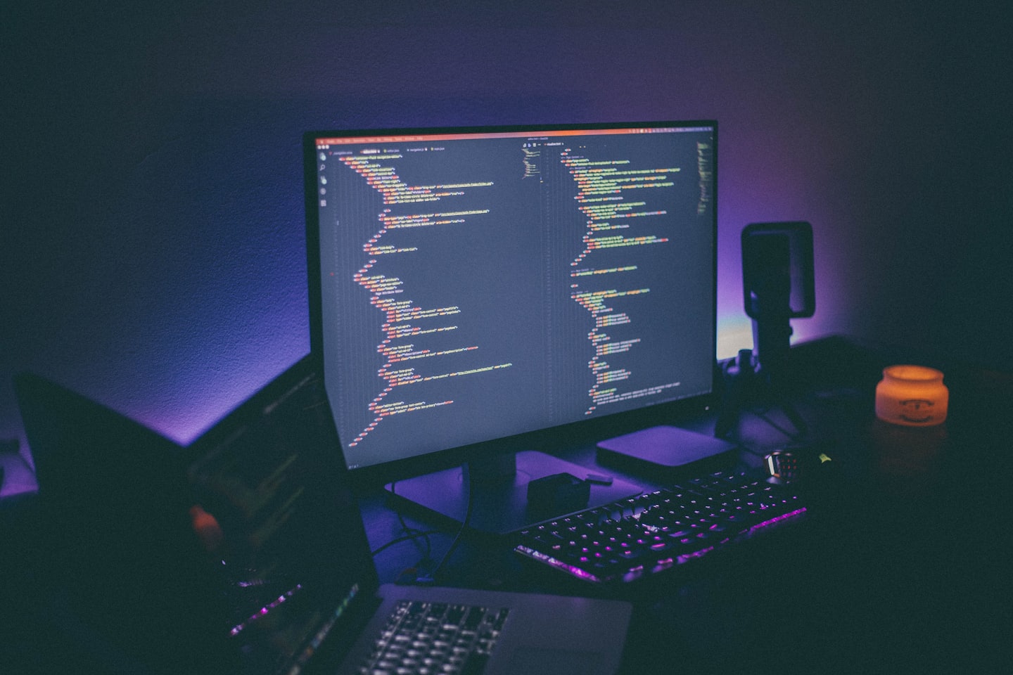 Developer's glowing computer screen with code at night.