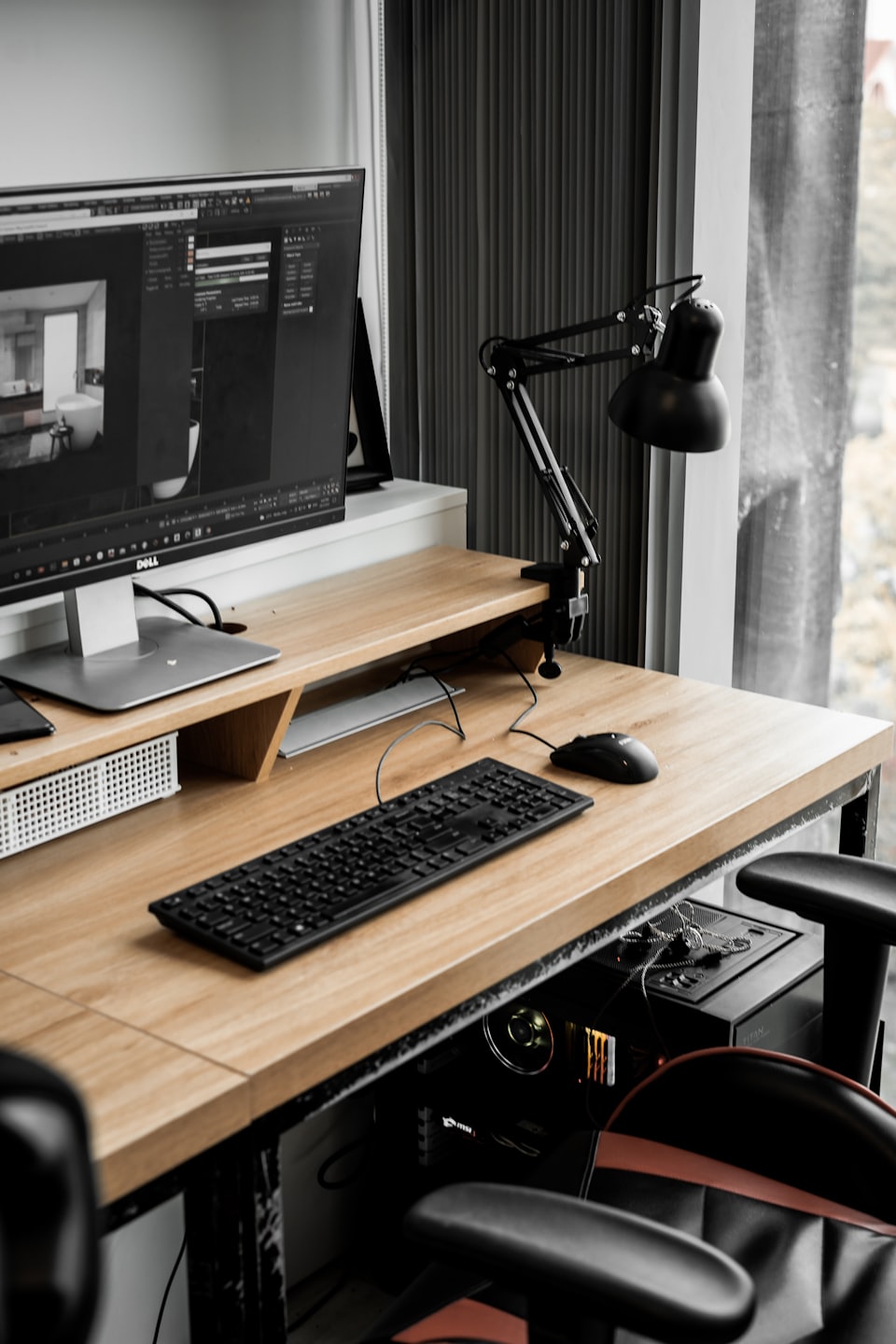 Computer workstation with 3D architectural design on screen.
