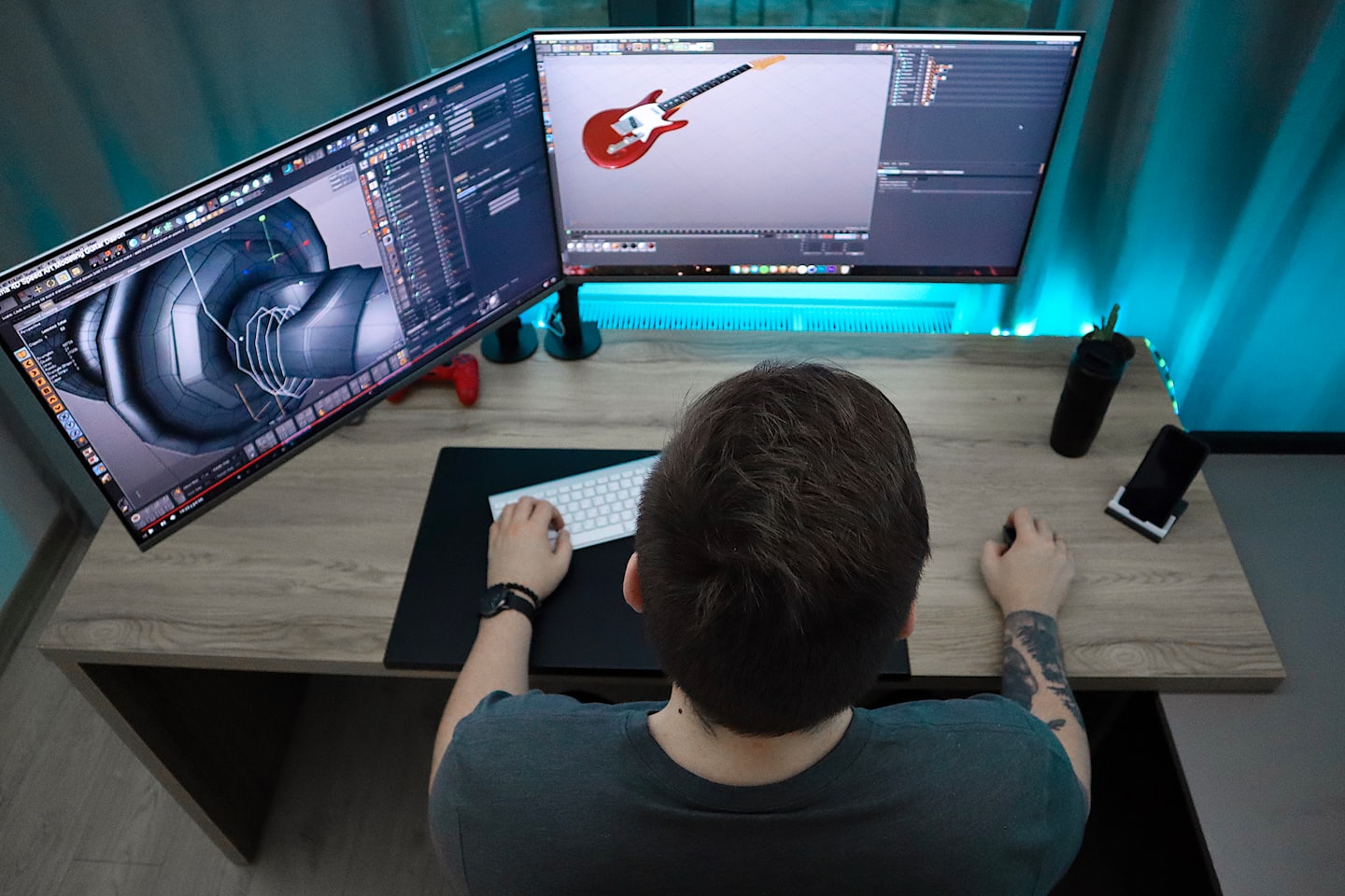 Person models a mechanical part and guitar on 3D software.